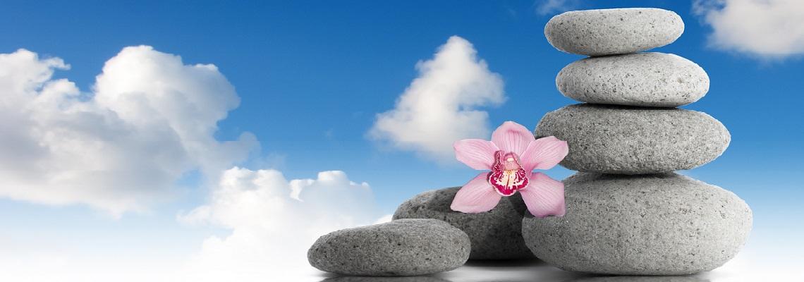Zen stones and orchid flower with blue sky and clouds background